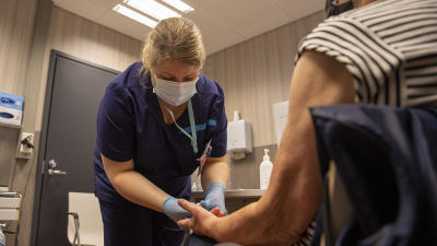 En sjuksköterska tar blodprov på en patient.