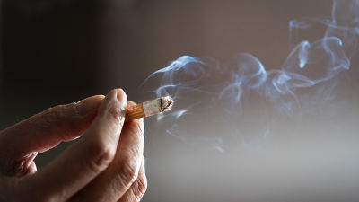 En närbild av en hand som håller i en cigarett.