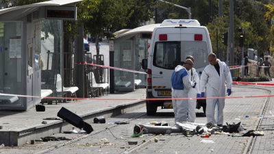 Israeliska poliser undersöker platsen i Jerusalem där en palestinier körde in i en folkmassa med bil den 5 november 2014.
