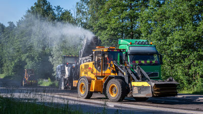 Män och maskiner jobbar med att asfaltera