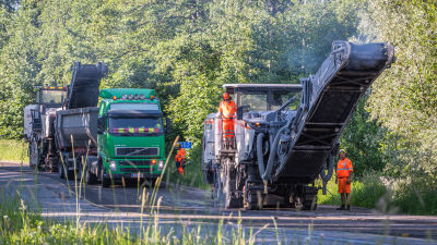 Män och maskiner jobbar med att asfaltera