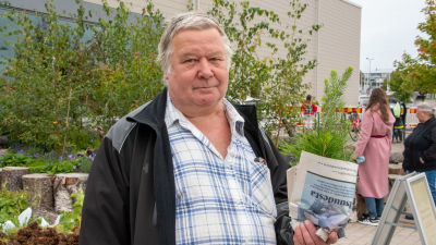 Hannu Lehto håller i gran- och tallplantor inlindade i tidningspapper.
