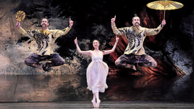 Tre balettdansare som ska föreställa kineser med fingrarna i vädret och solparasoll.
