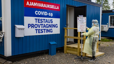 Tornion kaupungin koronatestauksen työntekijä siirtää kylttiä.