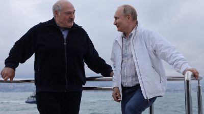 Aleksandr Lukasjenko och Vladimir Putin står på en båt och ler mot varandra.