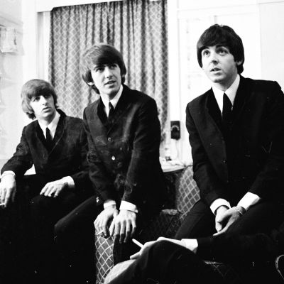 En pressbild på The Beatles klädda i kostymer.