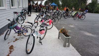 Cyklar framför en vit byggnad.
