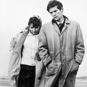 Nuori mies (Tom Courtenay) ja nainen kävelevät merenrannalla.