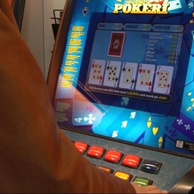 Anonym person spelar poker på en penningautomat