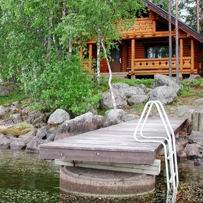 Hirsinen rakennus järven rannalla.