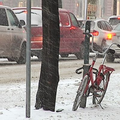Polkupyörä kadunvarressa ja autoruuhka