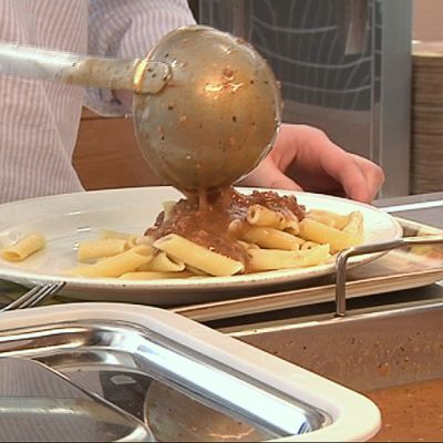Kuvassa ruokaa laitetaan lautaselle kouluruokalassa