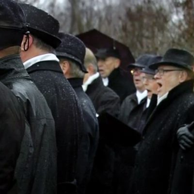 Mieskuoro laulaa Helsingin Tähtitorninmäellä.
