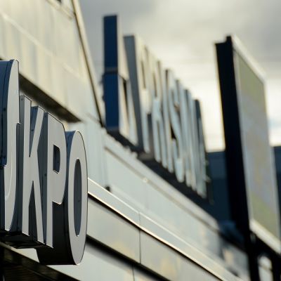 Kuvassa etualalla osuuskauppa KPO:n kyltti, taustalla Prisman kyltti.