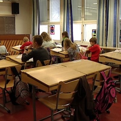 Ala-asteen oppilaita tunnilla pulpeteissa.