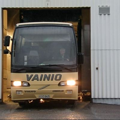 Linja-autoa ajetaan ulos korjaamosta.
