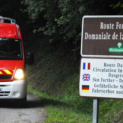 Hälytysajoneuvo tiellä, joka johtaa surmapaikalle Annecyjärven lähellä 5. syyskuuta 2012. 