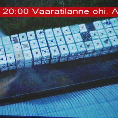Television ruudusta otetussa kuvassa pyörii kuvan ylälaidassa viranomaisten hätätiedote, jossa kerrotaan että Vihtavuoren vaaratilanne on ohi.