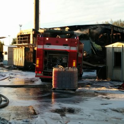Paloauto palaneen varastorakennuksen edessä