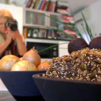 Bloggaaja Johanna Koskiranta kuvaa asetelmaa keittiössään Hellan ja viinilasin välissä-blogiaan varten