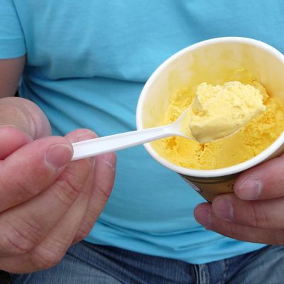 Jäätelöä kupissa ja lusikassa. Mango-meloni on hellepäivien suosikkimakuja.