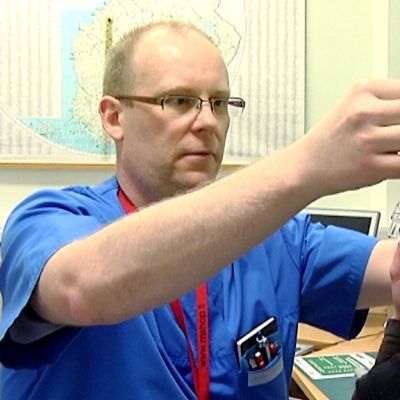 Vuoden Unihoitaja Markku Keski-Rahkonen sovittaa potilaalle ylipainemaskia.