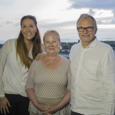 Toimittaja Sanna Kähkönen seisoo Tuula ja Pertti Markkulan kanssa pariskunnan parvekkeella.
