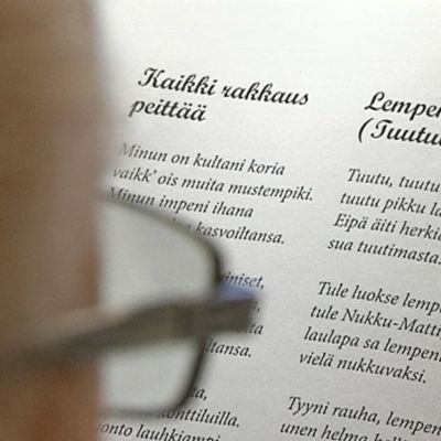 Kuvassa lihminen selaa kirjaa, josta näkyy tekstiä.