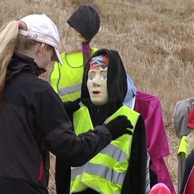 Päivi Kauhanen korjaa Porintien varressa seisovaa koululaishahmoa.