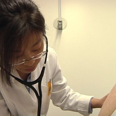 Pekingistä Suomeen muuttanut Bei Wang tutkii potilasta.