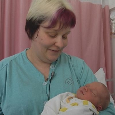 Nainen vauva sylissä synnytyssairaalan osastolla.
