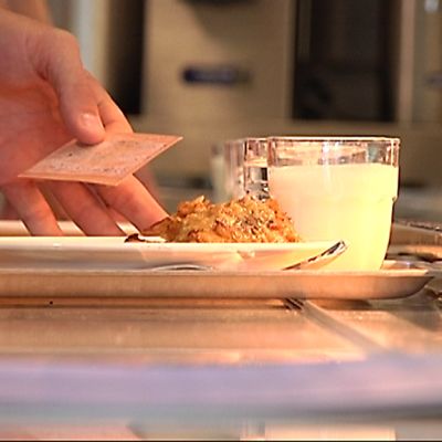 Opiskelijan lautasella ruokaa ja kädessä opiskelijakortti