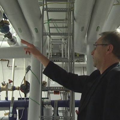 Mies osoittaa putkea Vesi-instituutissa