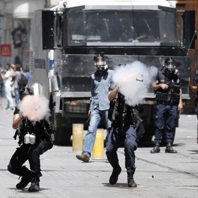 Turkin mellakkapoliisi käytti kyynelkaasua ja vesitykkejä hajaannuttaakseen mielenosoittajia Taksim-aukiolta Istanbulissa 1. toukokuuta 2013.
