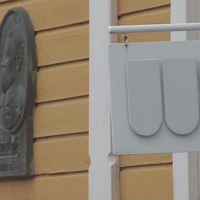 VB-valokuvakeskuksen kyltti ja Victor Barsokevitschin muistolaatta rakennuksen seinässä.