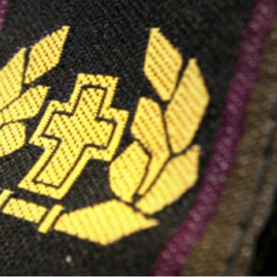 Kirkollisen työn tunnusmerkki maastopuvun hihassa.