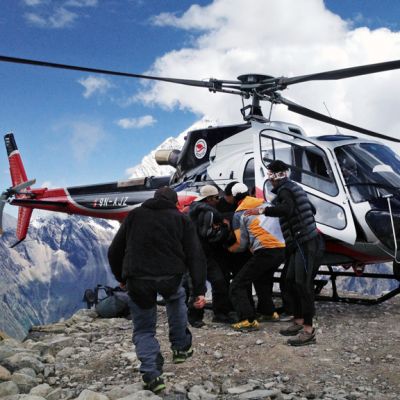 Lumivyöryssä loukkaantunutta kiipeilijää kannetaan pelastushelikopteriin  Manaslun vuorella Nepalissa.