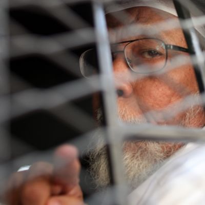 Abu Bakar Bashir istuu kaltereilla varustetussa poliisiautossa.