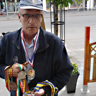 Kuvassa Antero Pohjonen kannattelee World Transplant Games -kisoista saamiaan mitaleita.