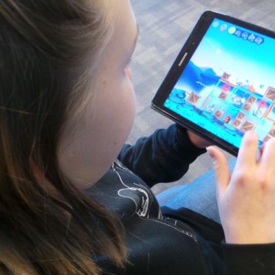 tyttö pelaa mobiilipeliä
