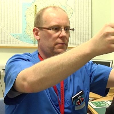 Vuoden Unihoitaja Markku Keski-Rahkonen sovittaa potilaalle ylipainemaskia.