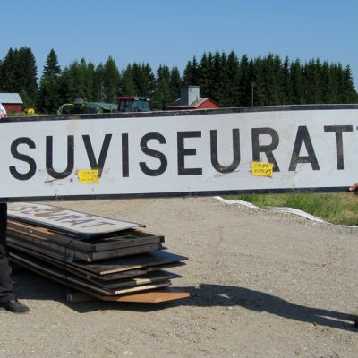 Ratilainen ja Nykänen kannattelevat suurta Suviseurat-kylttiä.