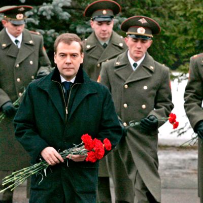 Medvedev ja sotilaita kukkia käsissään ja vakavina.