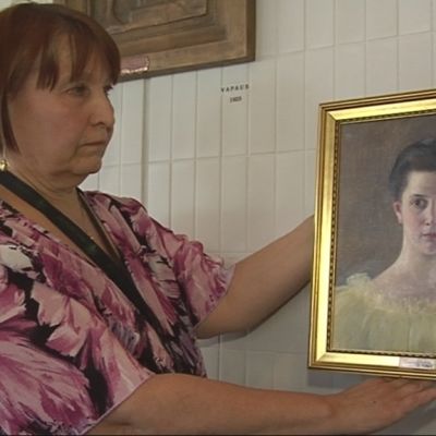 Iisalmen kulttuurisihteeri Tuula Laatikainen pitää Anna Sahlsténin maalausta.