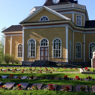 Kaustisen sankarihautausmaa, taustalla kirkko