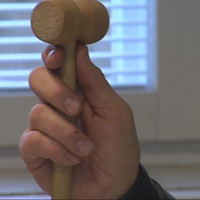 Meklari pitää nuijaa kädessään huutokaupassa.