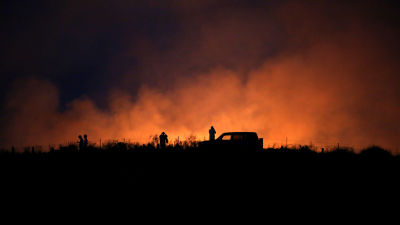 Israeler beskådar elden som uppkommit efter en raketattack nära Gazaremsan den 8 juli 2014.