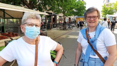 Britta Sunde och Maria Nyman, två damer med glasögon och vita t-skjortor stor en somrig sommardag på en gågata.