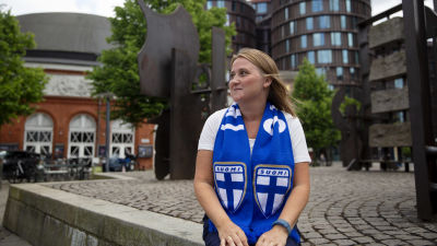Kvinna i finska blåvita supporterfärger.