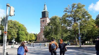 Tre unga går över ett övergångsställe vid Åbo Domkyrka.